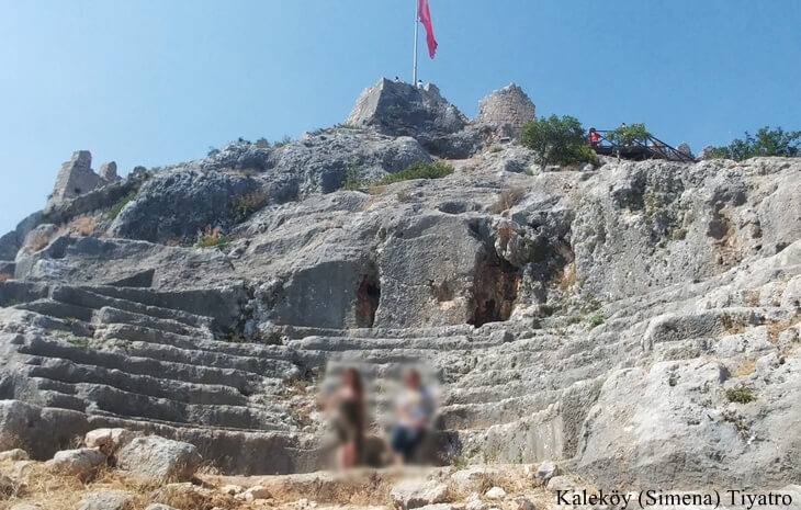 Kalek&ouml;y (Simena) Kalesi yamacına oyulmuş k&uuml;&ccedil;&uuml;k antik tiyatro basamakları ve arka planda dalgalanan T&uuml;rk bayrağı