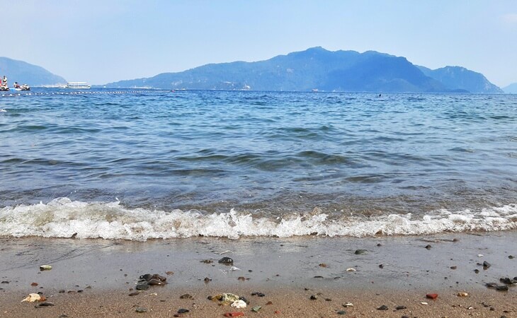 Marmaris Halk Plajı’ndan Ege Denizi manzarası ve uzaktaki dağ silueti