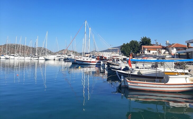 Marmaris Selimiye&rsquo;de limana bağlı tekneler ve yelkenliler, berrak deniz &uuml;zerinde yansımalarıyla birlikte sakin bir sabah manzarasında g&ouml;r&uuml;l&uuml;yor.